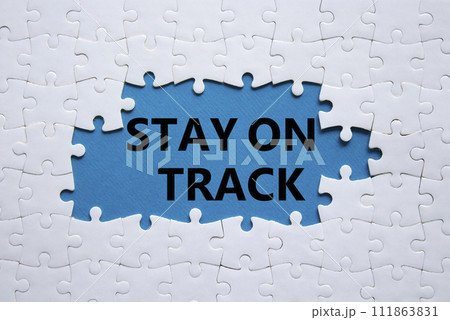 Stay on track symbol. Concept words Stay on track on white puzzle. Beautiful blue background. Business and Stay on track concept. Copy space. Stay on track symbol. Concept words Stay on track on white puzzle. Beautiful blue background. Business and Stay on track concept. Copy space. 111863831