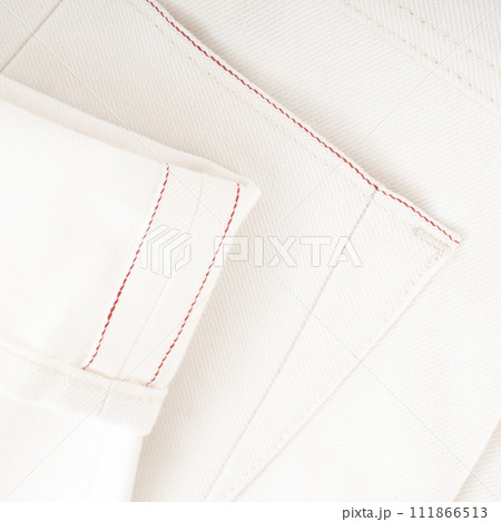 Detail of the bottom of milky raw denim jeans with red selvedge Detail of the bottom of milky raw denim jeans with red selvedge 111866513
