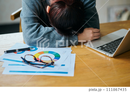 デスクで塞ぎ込む若い女性 111867435