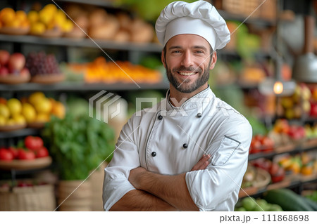 Chef smiling with crossed arms in front of fresh produce 111868698