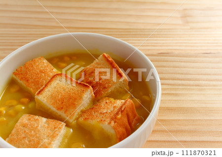 ボウルに入った粒入りコーンスープとカットしたトースト ボウルに入った粒入りコーンスープとカットしたトースト 111870321