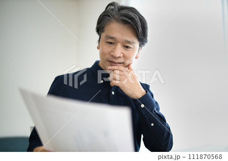リビングでテレワークをするミドル男性 リビングでテレワークをするミドル男性 111870568