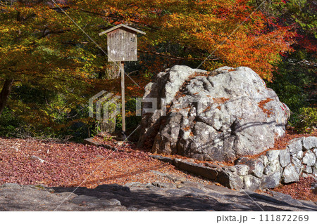 秋の京都高雄　神護寺　紅葉に包まれた硯石 111872269