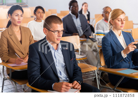 Man listening to speaker on business training in conference hall Man listening to speaker on business training in conference hall 111872858