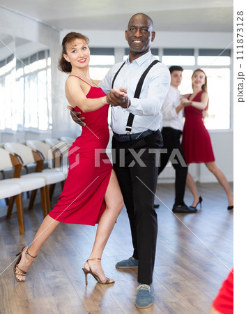 African man and woman dancing waltz in couple during lesson at studio 111873128