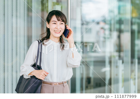 スマホで通話しながら大企業に出社・通勤・出勤する充実したビジネスウーマン・キャリアウーマン 111877999
