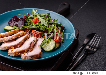 Delicious dietary salad with arugula, cucumber and cherry tomatoes and chicken breast slices Delicious dietary salad with arugula, cucumber and cherry tomatoes and chicken breast slices 111880998