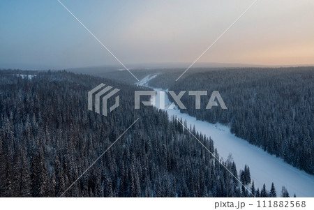 snowy coniferous forest and snow river under morning frosty fog 111882568