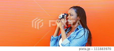 Portrait of happy smiling african woman photographer with film camera 111883970