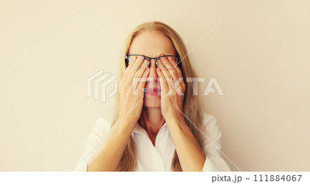 Tired overworked woman employee rubbing eyes suffering from dry eye syndrome after work 111884067