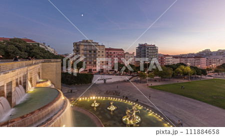 Panorama showing lawn at Alameda Dom Afonso Henriques and the Luminous Fountain aerial day to night timelapse in Lisbon. 111884658