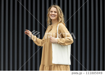 A girl in a summer outfit with a reusable shopping bag. A girl in a summer outfit with a reusable shopping bag. 111885049