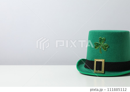 Green hat with clover leaf on white background, space for text Green hat with clover leaf on white background, space for text 111885112