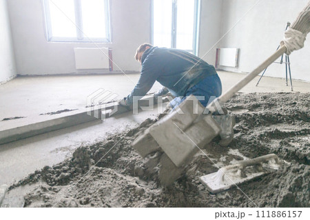 A builder in work clothes is doing his job A builder in work clothes is doing his job 111886157