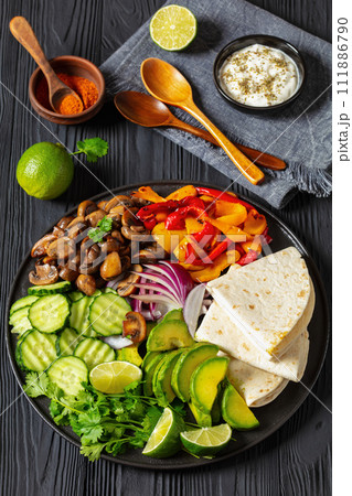 vegan fajitas with mushrooms, veggies on a plate vegan fajitas with mushrooms, veggies on a plate 111886790