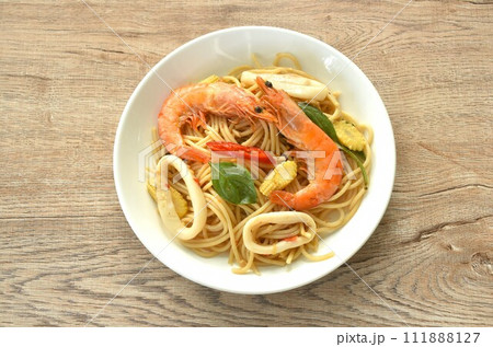 spicy stir fried spaghetti seafood couple squid shrimp with chili and basil leaf in sauce on plate spicy stir fried spaghetti seafood couple squid shrimp with chili and basil leaf in sauce on plate 111888127