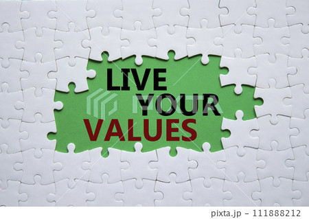 Live your values symbol. Concept words Live your values on white puzzle. Beautiful green background. Business and Live your values concept. Copy space. 111888212