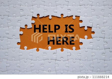 Help is here symbol. Concept words Help is here on white puzzle. Beautiful orange background. Business and Help is here concept. Copy space. 111888214