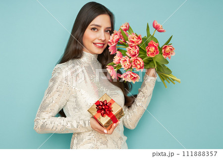 Woman hold bouquet of flowers and golden gift box Woman hold bouquet of flowers and golden gift box 111888357