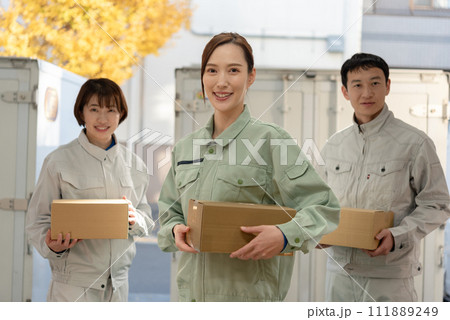 荷物を持つ作業服姿の男女 111889249