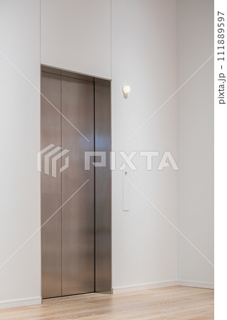 白い空間にあるシンプルなエレベーター 111889597
