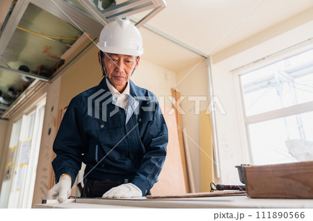 作業台で作業をする大工さん 111890566