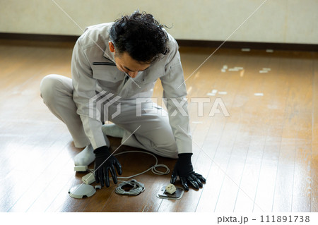 床に配線工事をする作業員 111891738