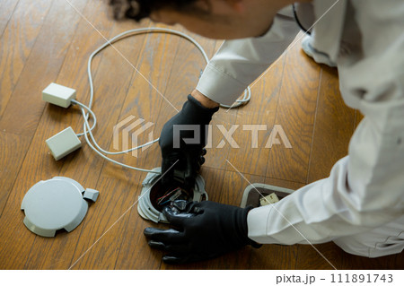 床に配線工事をする作業員 111891743