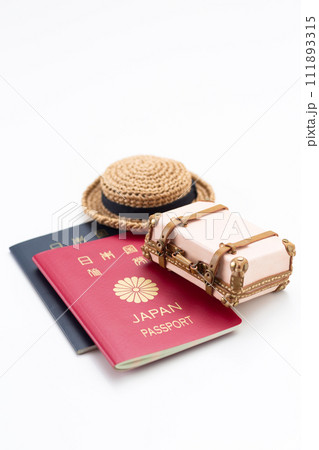 旅行鞄のトランクケースとパスポートと麦わら帽子 111893315