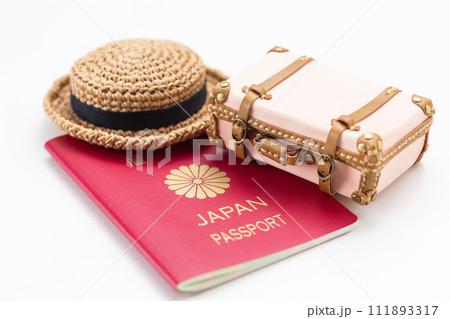 旅行鞄のトランクケースとパスポートと麦わら帽子 111893317