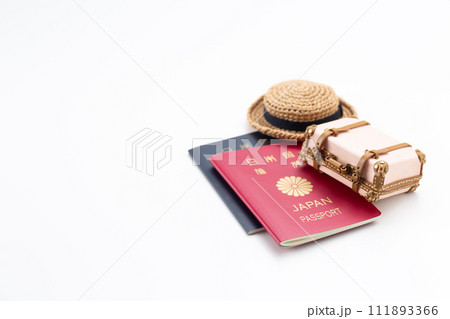 旅行鞄のトランクケースとパスポートと麦わら帽子 111893366