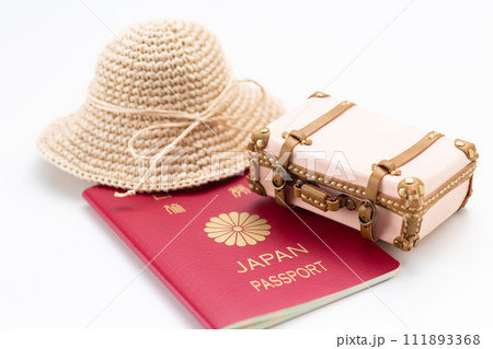 旅行鞄のトランクケースとパスポートと麦わら帽子 111893368