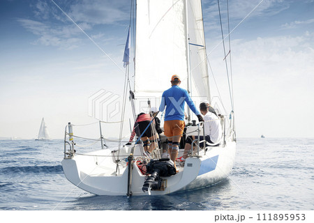 Crew on sailboat during regatta Crew on sailboat during regatta 111895953