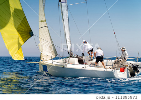 Sailing boat in light wind during regatta competition 111895973
