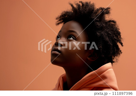 African American serious teenage girl wearing hoodie on peach background 111897396