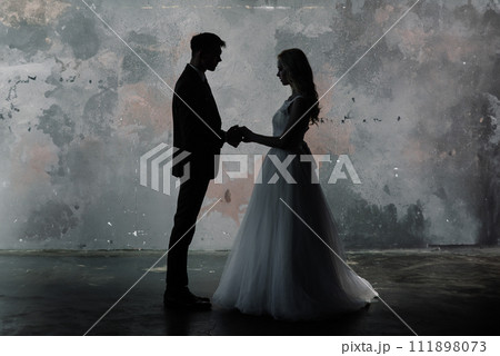 Cute wedding couple in the interior of a classic studio decorated. Cute wedding couple in the interior of a classic studio decorated. 111898073