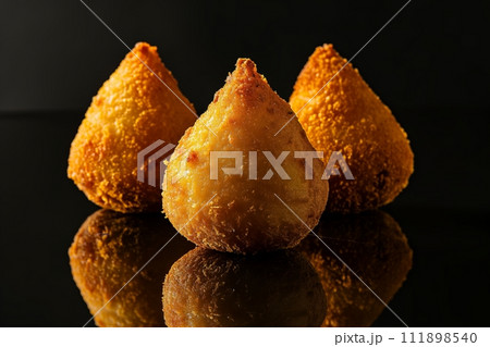 Coxinha, traditional Brazilian snack, stuffed with chicken and fried on black background 111898540