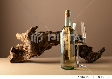 White wine and old snag on a beige background. 111898887