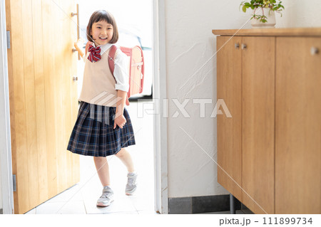 玄関に立つ小学生の女の子 111899734