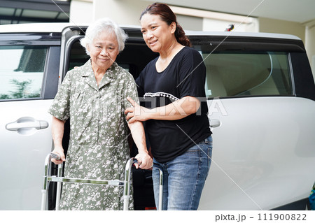 Caregiver help Asian elderly woman disability patient get in her car, medical concept. 111900822