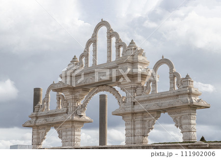 Architectural design of archway Neasden temple (BAPS Shri Swaminarayan Mandir) against a nice cloud sky background. 111902006
