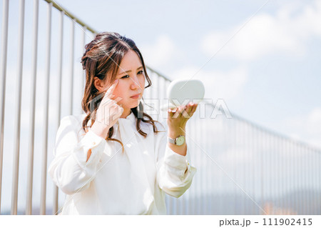 化粧直し・メイク直しをする女性(目尻,目元,シワ,皺,アンチエイジング) 化粧直し・メイク直しをする女性(目尻,目元,シワ,皺,アンチエイジング) 111902415