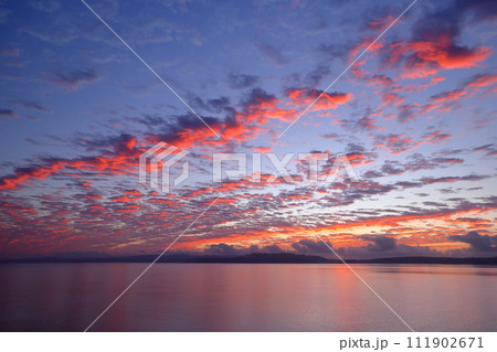 沖縄県国頭郡今帰仁村　古宇利島と沖縄本島方面の屋我地島を結ぶ古宇利大橋からの朝焼け空 111902671