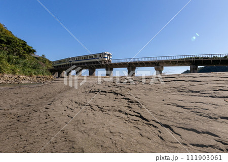 砂模様と青空の下鉄橋走るJR九州日南線白色いDLキハ40 111903061