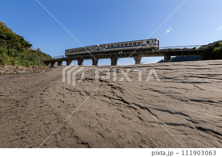 砂模様と青空の下鉄橋走るJR九州日南線白色いDLキハ40 111903063