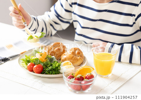 朝食を食べる女性の手元 111904257