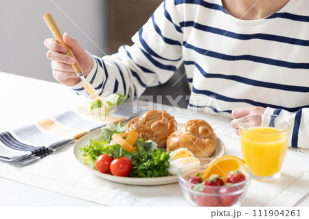 朝食を食べる女性の手元 111904261