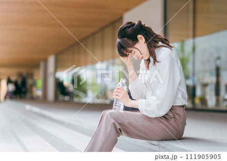 ビジネス街・商業施設で座って落ち込むビジネスウーマン・ワーキングママ 111905905
