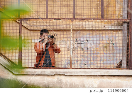 Journalist photographing abandoned buildings in old city area for news article 111906604