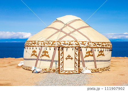 Traditional Yurt. National nomadic old house of Central Asia with blue sky on background. Issyk Kul high alpine lake in the Tian Shan Mountains. Kyrgyz ger camp for tourists of Kyrgyzstan. 111907902